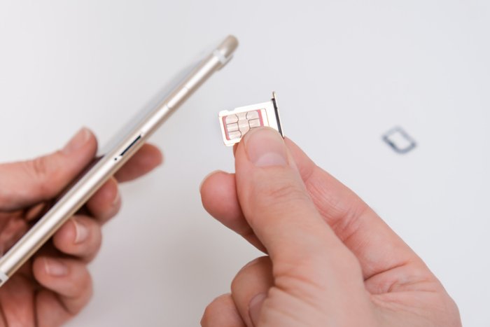 A SIM card being put into a mobile phone.